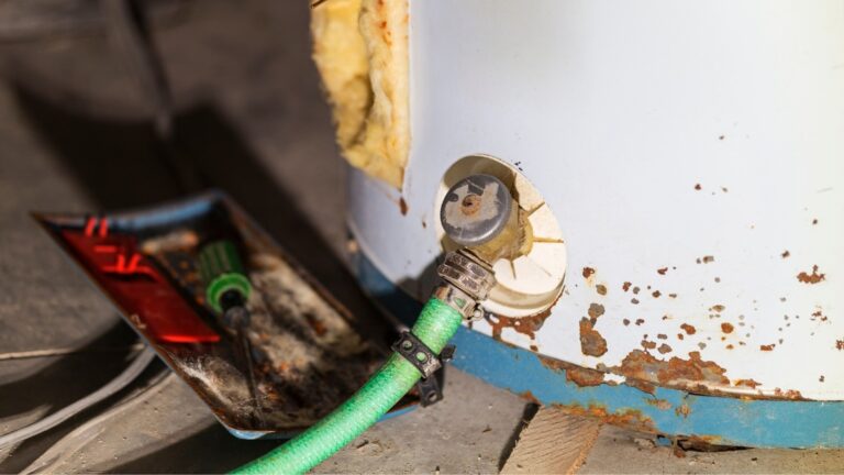 An older water heater with rusted spots and broken insulation.